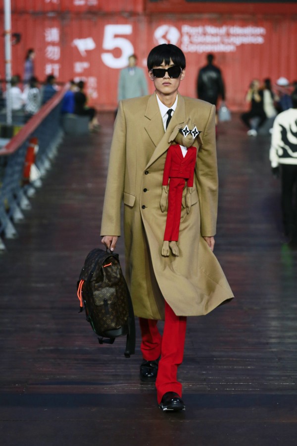 Modelo com casaco bege desfilando no Desfile Louis Vuitton em Shanghai